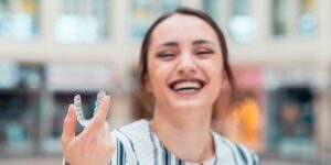 Lady Showing Invisalign Product - Wall Street Dental Spa NYC